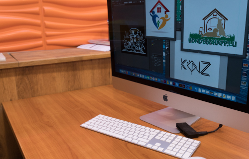Arbeitsplatz im Evodruck Grafikstudio mit verschiedenen Logoprojekten